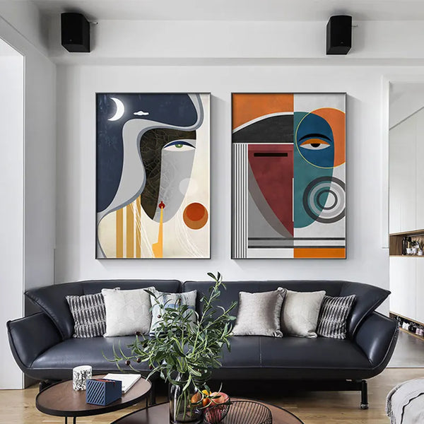 Dans un salon moderne et chic, sont exposées deux toiles de style peinture cubique coloré de visage. 