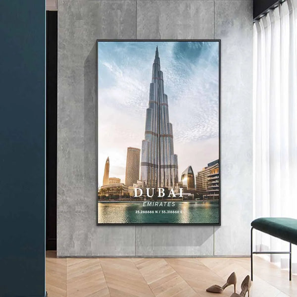 Une toile représentant une impression d'une photographie d'une tour à Dubaï est affichée dans une salon. Le salon est dans les tons de gris avec un parquet à chevrons au sol. La banquette est en velours vert et il y a aussi une paire d'escarpins. 