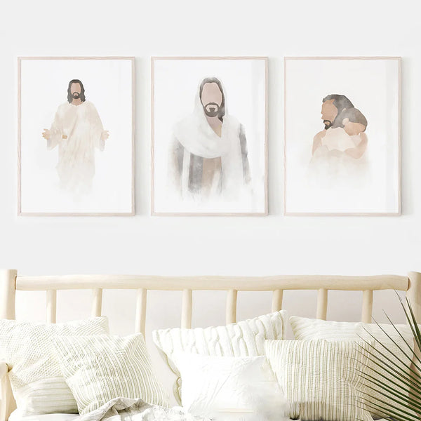 Dans une chambre bohème et épurée dans les tons de blanc et bois, trois toiles sont affichées. Les toiles représentent des aquarelles de Jesus. 