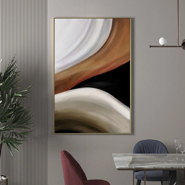 Dans une salle à manger chic une toile est affichée. La toile est faite de vagues en peinture dans différentes couleurs noir, blanc et marron. 