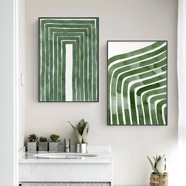 Dans une salle de bain au dessus d'un petit lavabo en marbre, se trouvent deux toiles avec des lignes géométriques peintes en aquarelle verte sur fond blanc. 