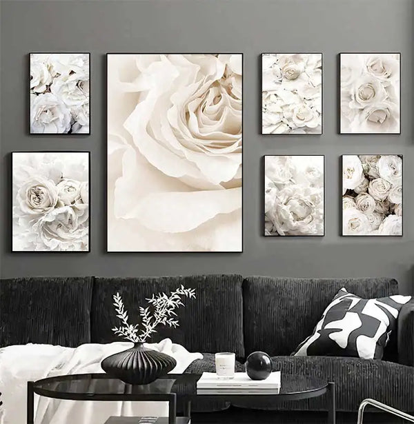 Dans un salon noir et blanc, de style moderne et design, sont affichées des toiles représentant des photos de fleurs blanches. 