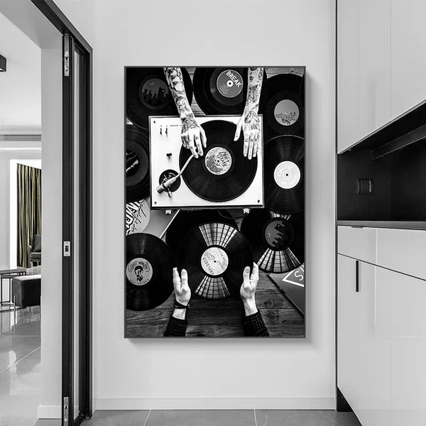 Dans une cuisine très contemporaine blanche laquée est installée une toile en noir et blanc de deux personnes dont on ne voit que les mains, mettre des disques dans un tourne disque. 
