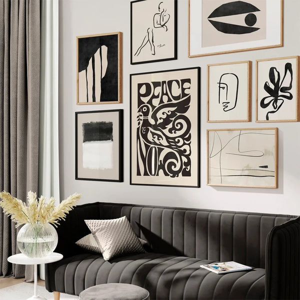 Dans un salon ay style noir et blanc moderne des tableaux noir et blanc abstraits sont affichés au dessus d'un canapé. Ils représentent des formes abstraites et donnent un style bohème. 