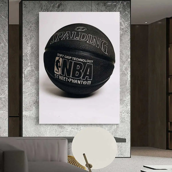 Dans un style au style très moderne avec des murs en marbre gris, est accroché une toile représentant une photo d'un ballon de basket. Le ballon est noir avec le symbole de la NBA dessus. 
