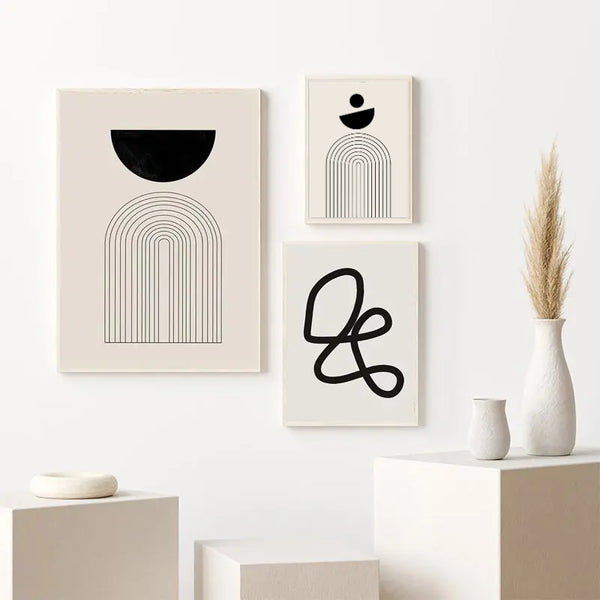 Trois tableaux de style scandinave minimaliste avec des formes géométriques noires et blanches sont accrochées dans un salon au style organique et épuré. 