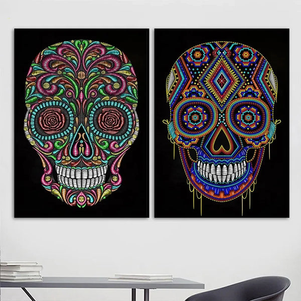 Dans un bureau, deux toiles sur fond noir avec des têtes de mort mexicaines colorées sont affichées. Le bureau est épuré et moderne. 